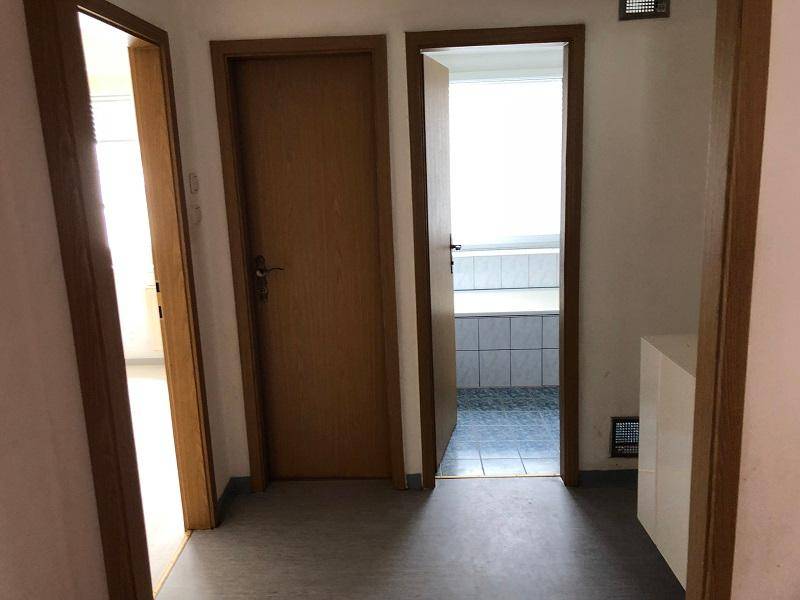 Flur mit Zugang zum Badezimmer und weiteren Zimmern, inklusive Heizungsanlage.