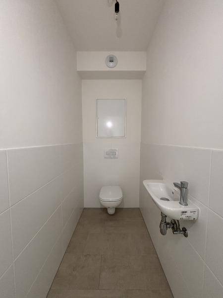 Gäste-WC mit wandhängendem WC und kleinem Waschbecken, modern und funktional gestaltet.