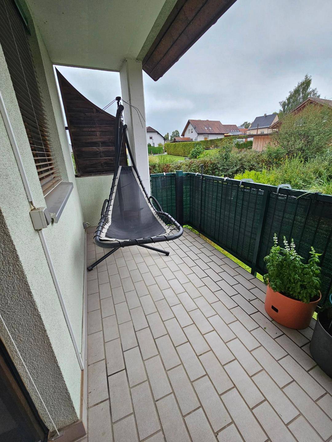 Gemütlicher Balkon mit Hängesessel und Blick ins Grüne.