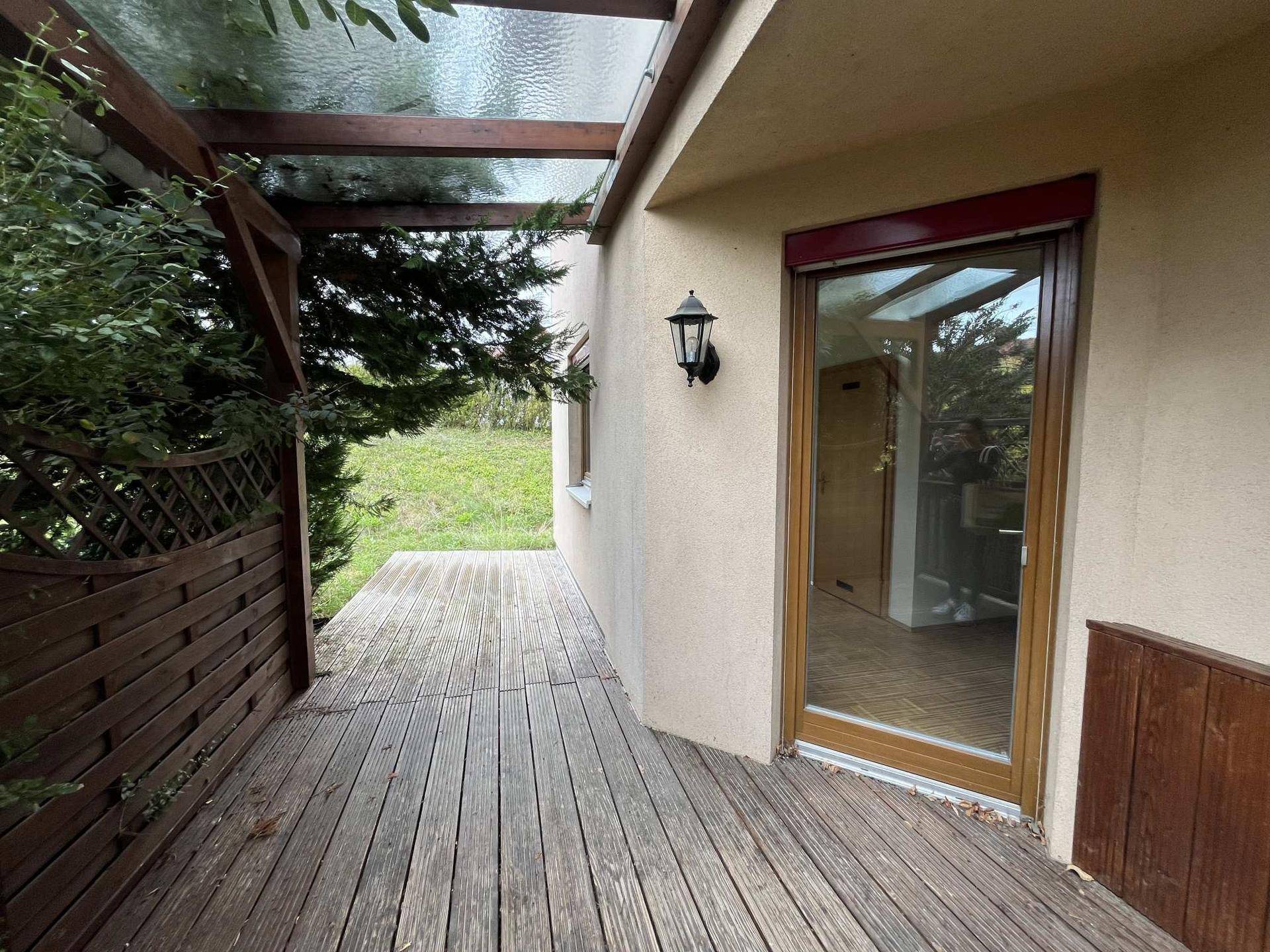 Überdachte Holzterrasse mit Blick ins Grüne, ideal für entspannte Stunden im Freien.