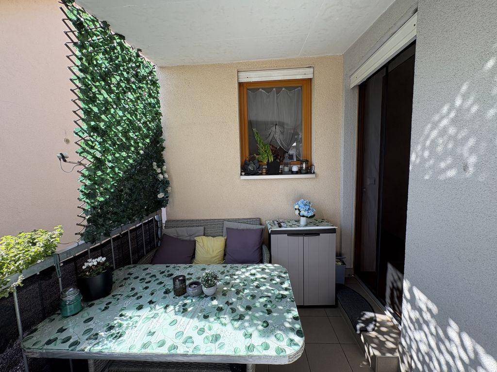 Möblierter Balkon mit Sitzgelegenheiten, Tisch und grüner Wanddekoration für entspannte Stunden.