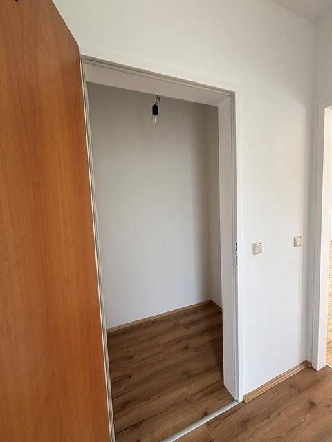 Kleiner Abstellraum mit Laminatboden und weißen Wänden, ideal für zusätzlichen Stauraum.