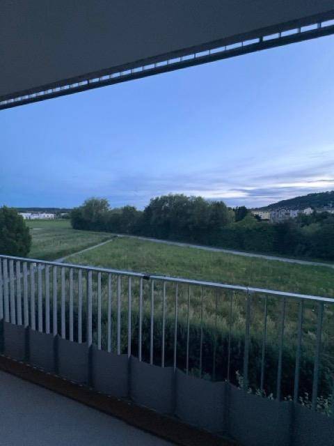 Balkon mit Panoramablick auf die weite, grüne Landschaft und den Himmel.