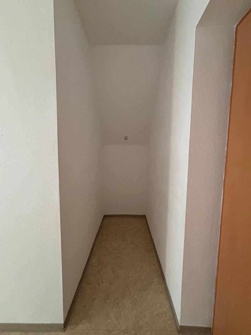 Kleiner, leerer Abstellraum mit hellen Wänden und einfachem Bodenbelag, ideal für zusätzlichen Stauraum.