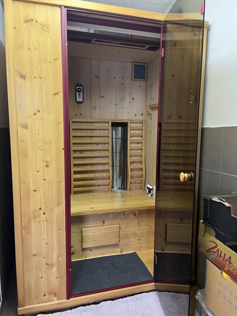 Private Holzsauna mit Glastür und Bänken für Entspannung.