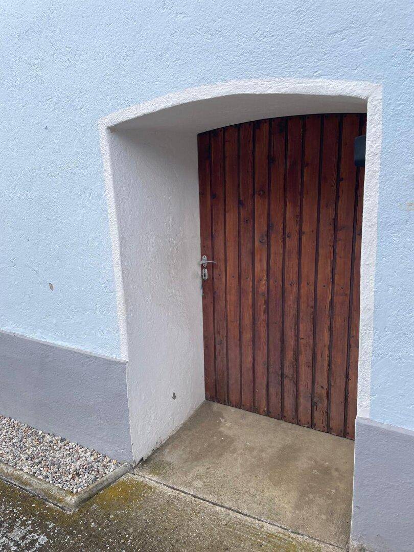 Holztür als Nebeneingang zum Haus mit einfacher Gestaltung.