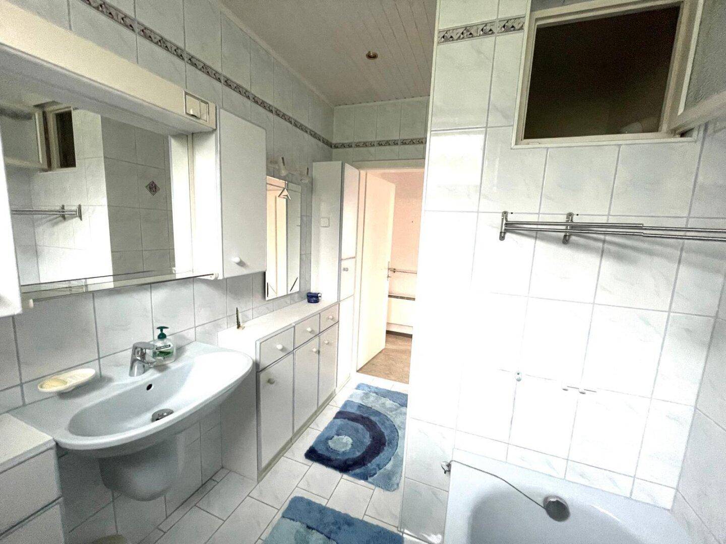 Badezimmer mit Waschbecken, Spiegelschrank und Badewanne.