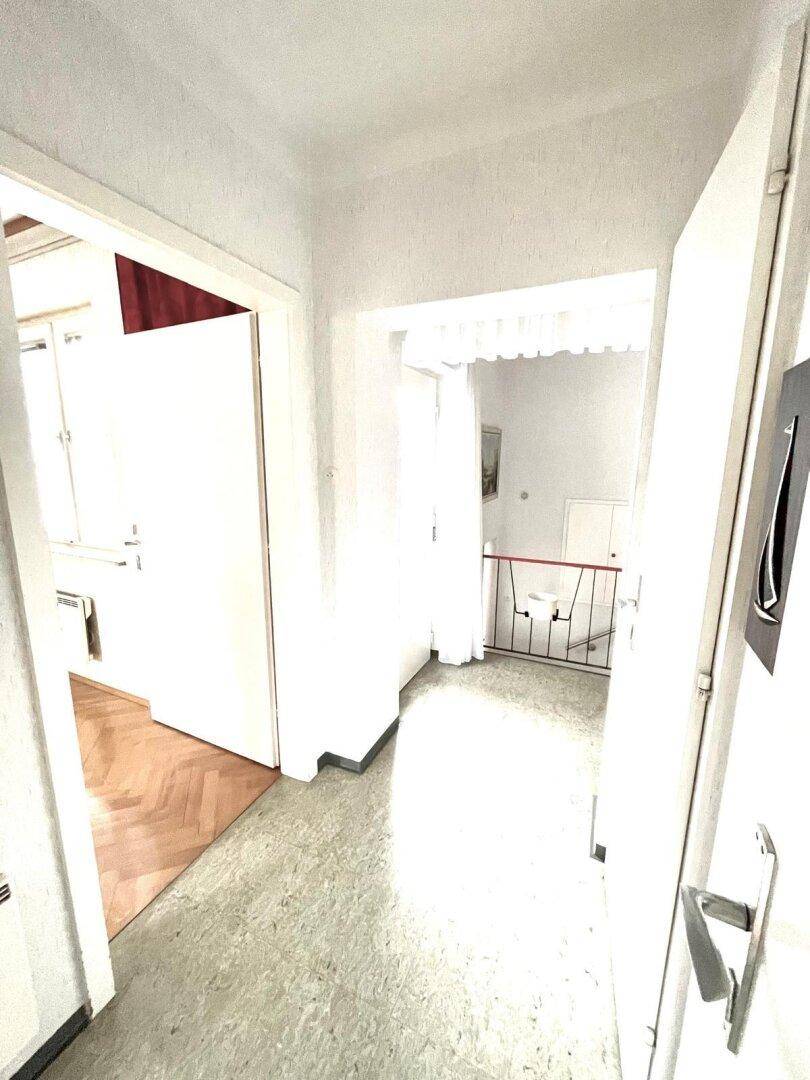 Heller Flur mit Treppe und Zugang zu den oberen Etagen.