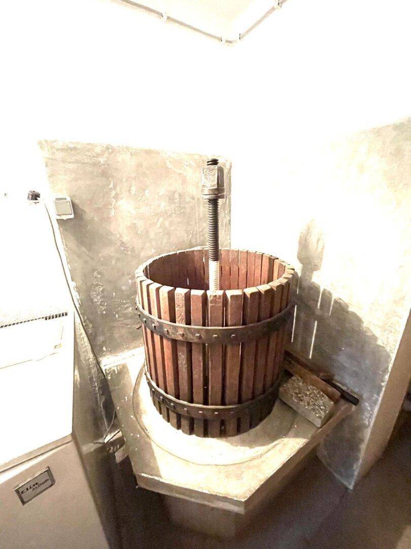 Kellerraum mit einer traditionellen Weinpresse.