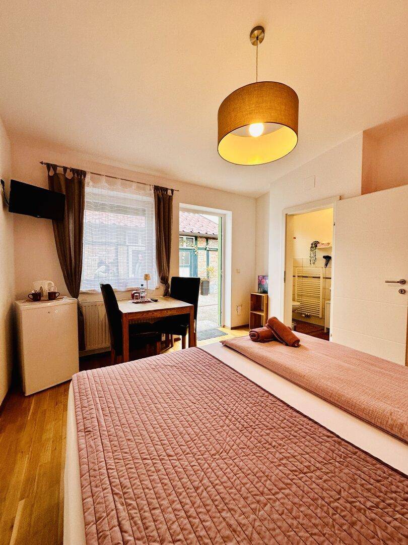 Helles Schlafzimmer mit Essbereich und Zugang zu einem charmanten Außenbereich.