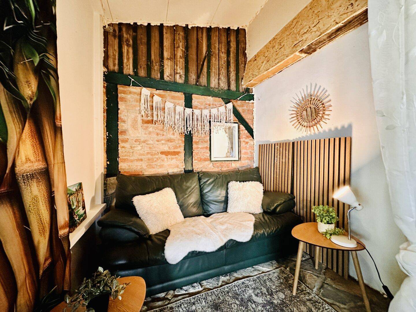 Gemütliche Sitzecke mit Sofa, freiliegendem Ziegelwerk und Holzverkleidung.