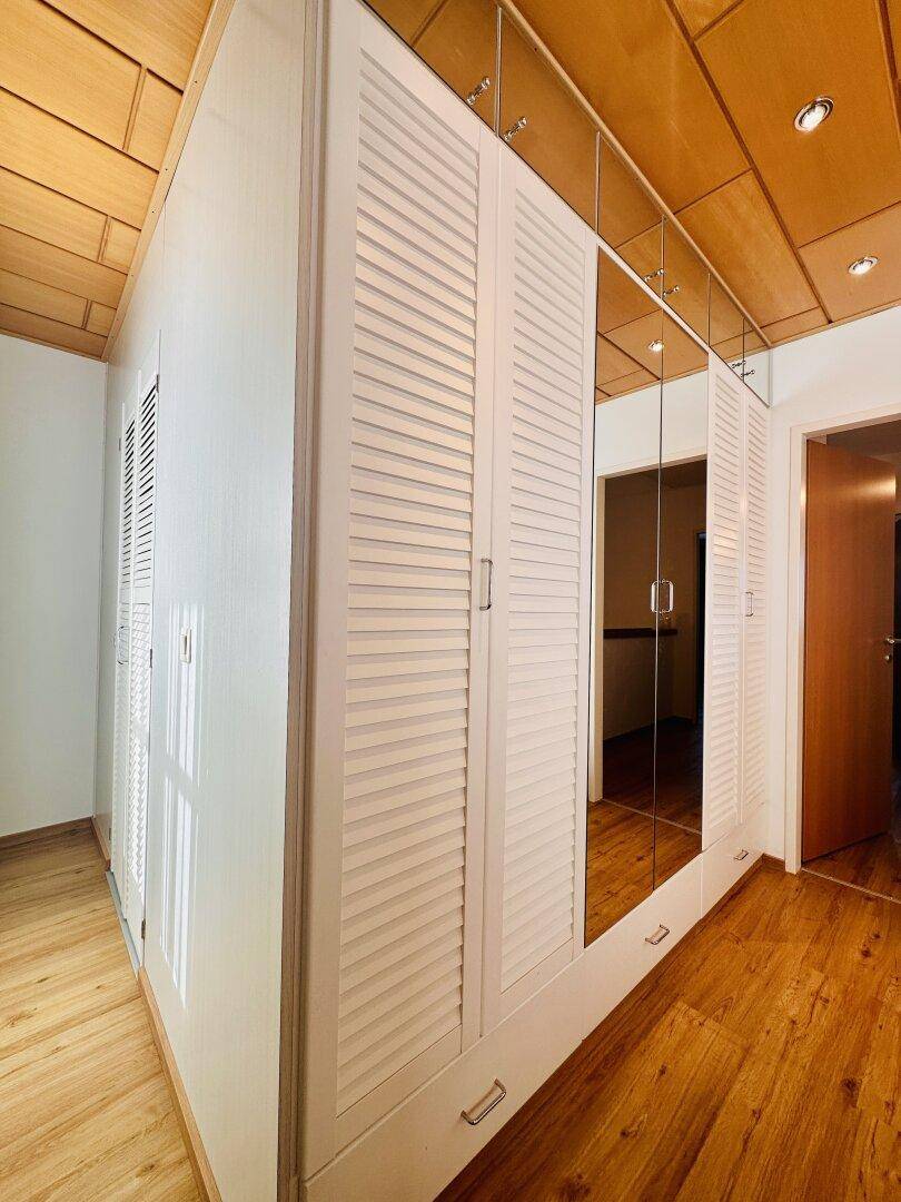 Großer Spiegelschrank im Schlafzimmer mit Holzdecke und Holzboden, bietet viel Stauraum.