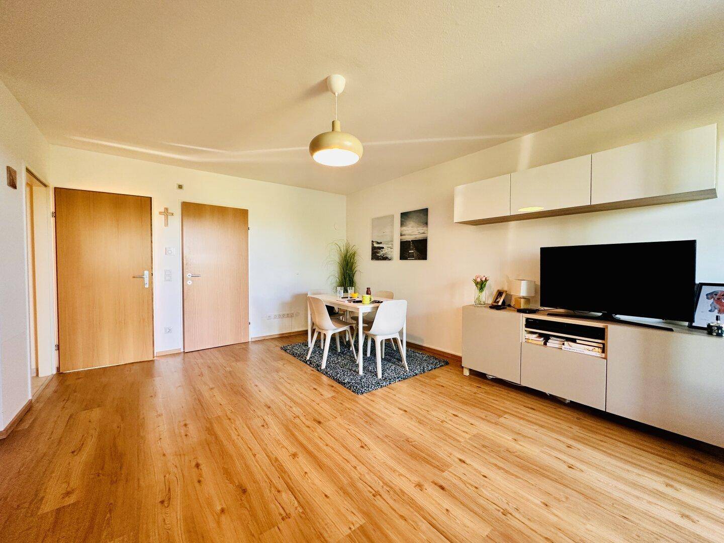 Essbereich mit modernem Esstisch und TV-Möbeln, integriert in den offenen Wohnraum.