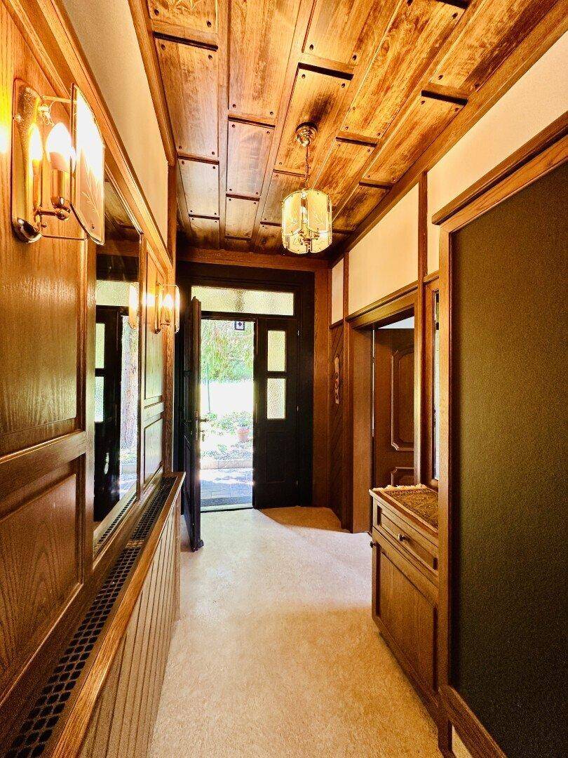 Gemütlicher Flur mit Holzvertäfelung und Deckenverkleidung im Landhausstil.