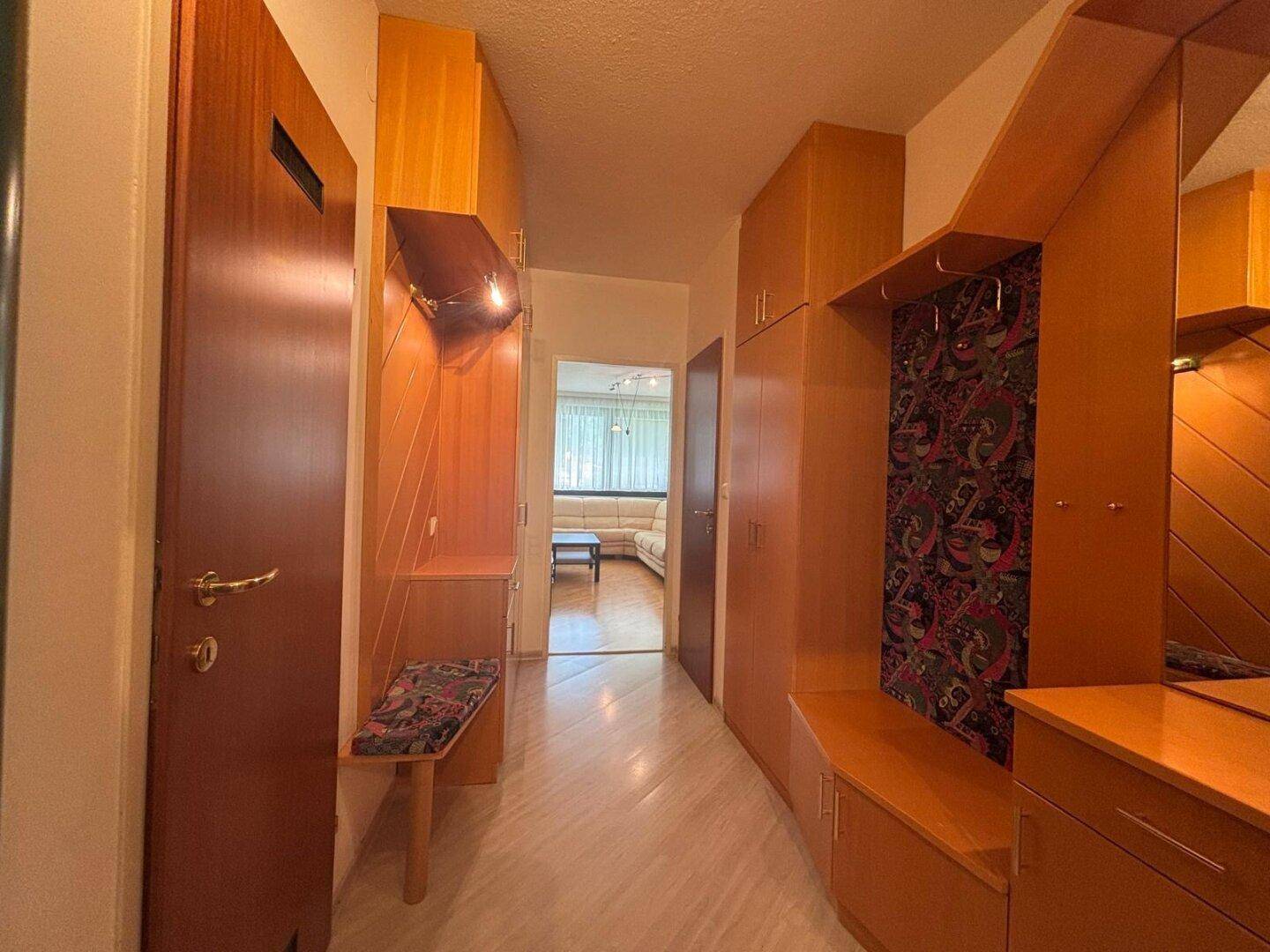 Eingangsbereich mit Garderobe, Holzboden und Zugang zu weiteren Räumen.
