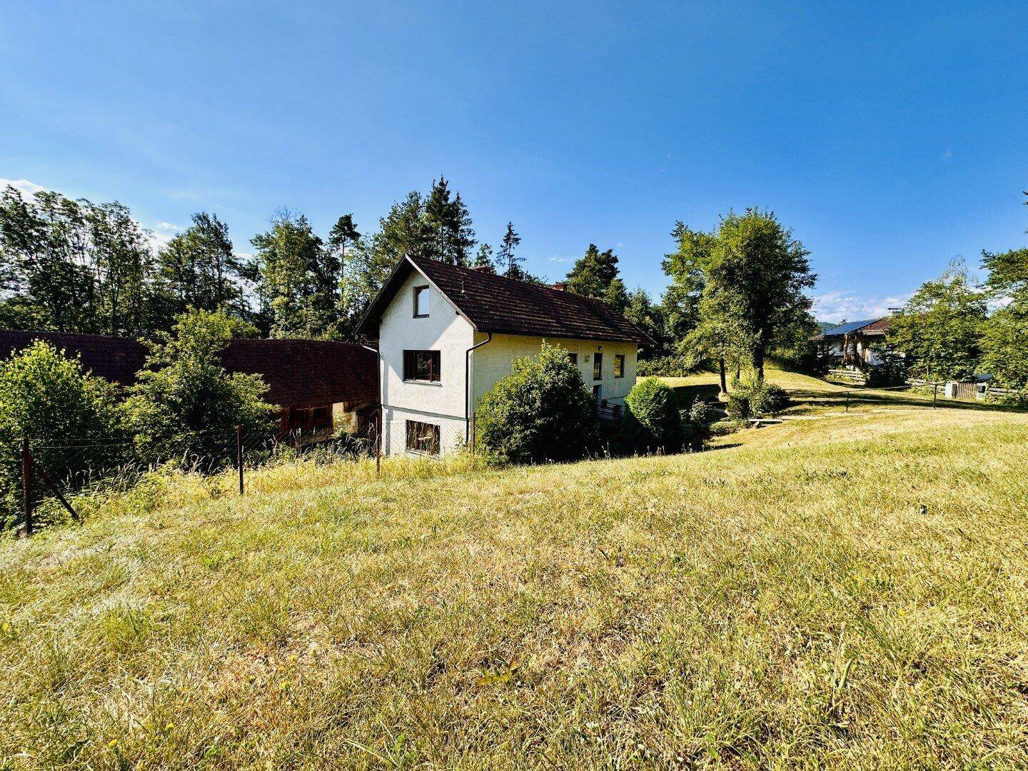 Freistehendes Haus in ländlicher Umgebung mit weitem Blick über Felder und Bäume.