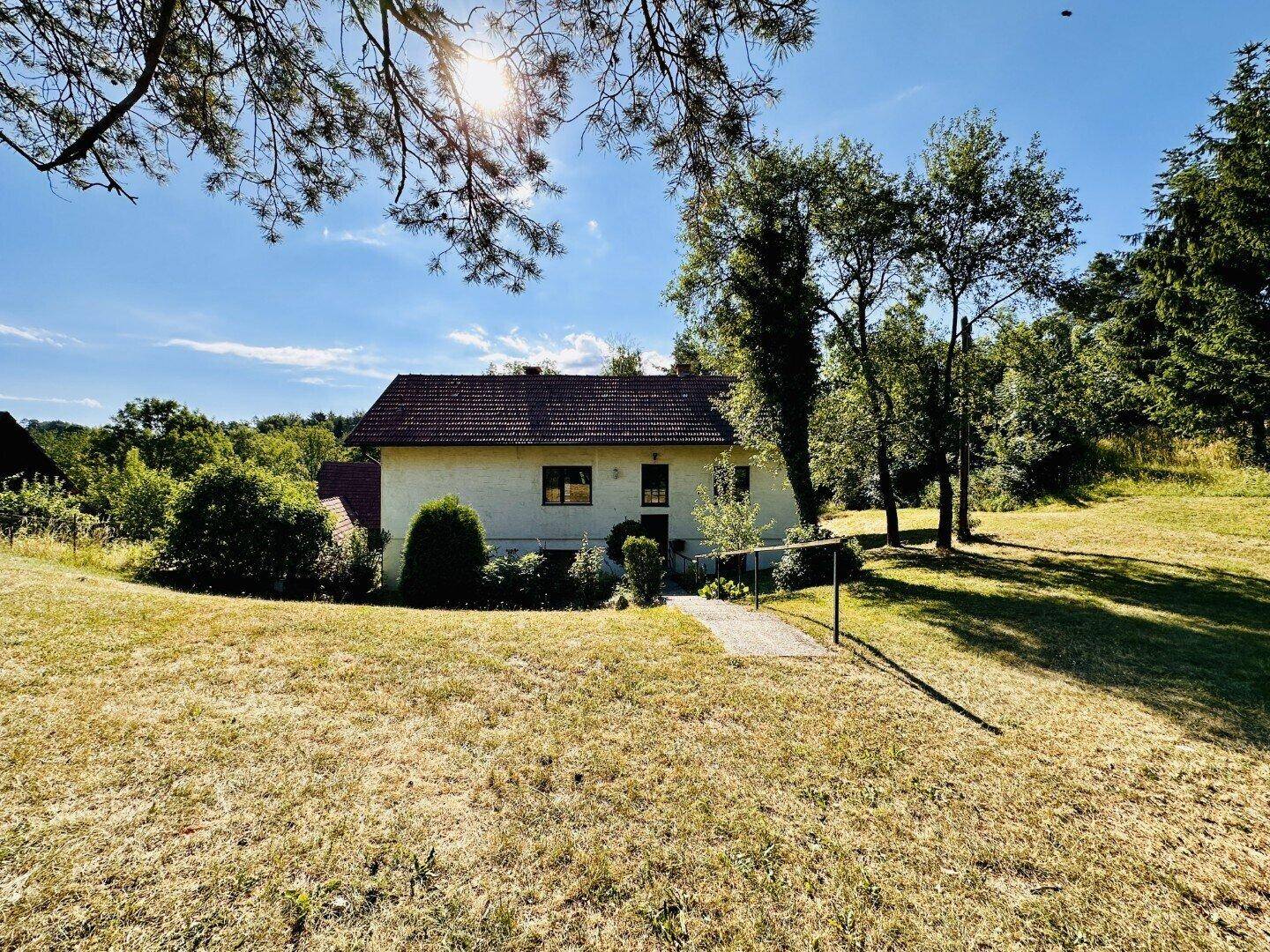 Freistehendes Haus in ländlicher Umgebung mit weitem Blick über Felder und Bäume.