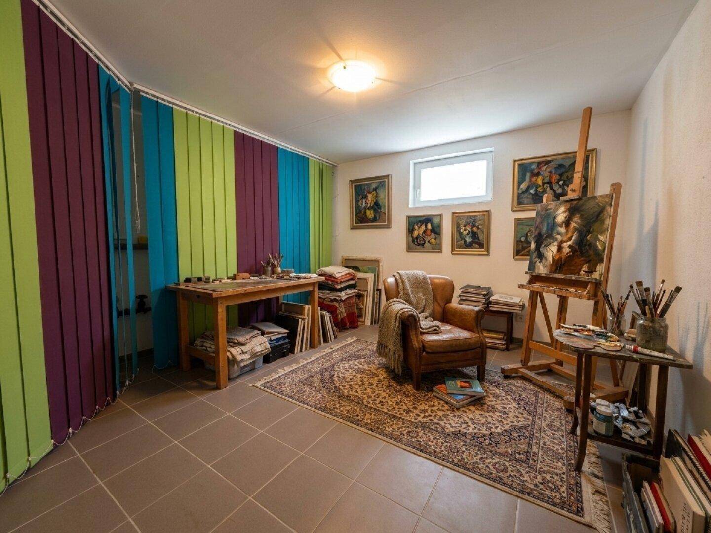 Kreativer Arbeitsraum mit Fliesenboden, Kunstwerken und bunten Vorhängen.