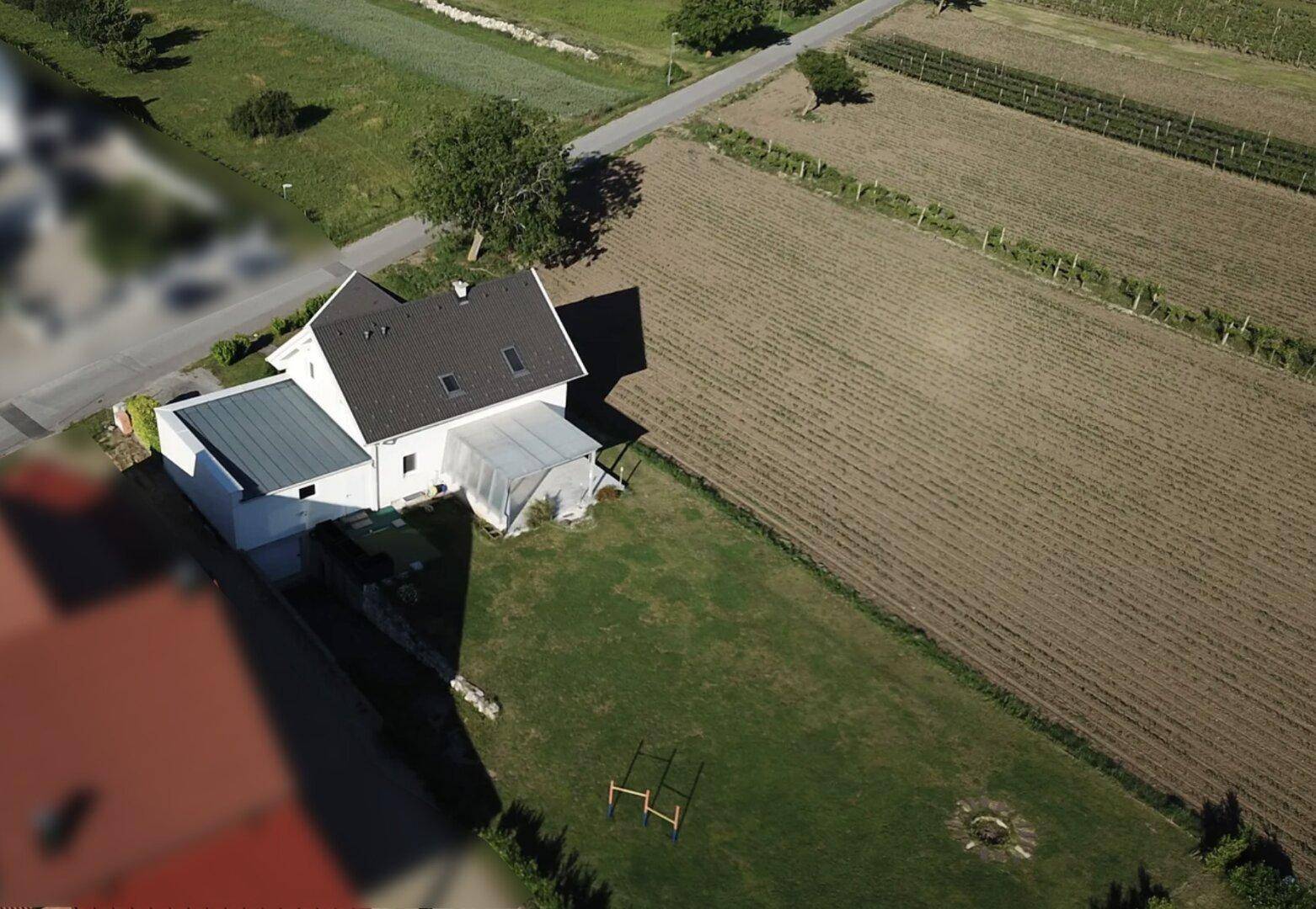 Luftaufnahme des Hauses mit umliegenden Feldern und ländlicher Umgebung.