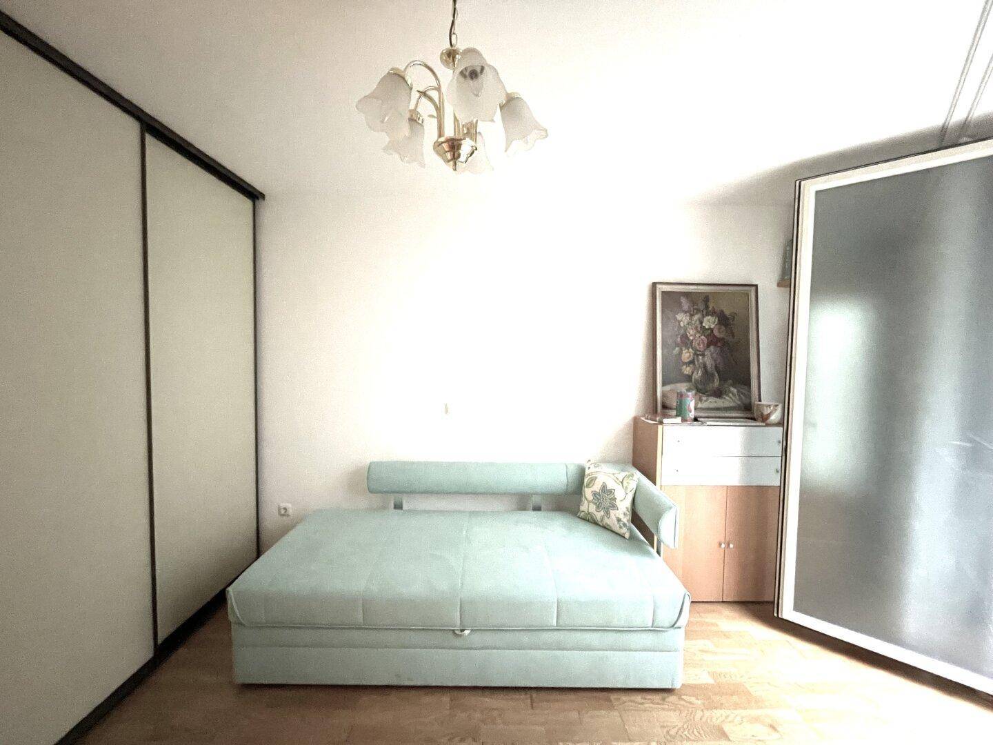 Schlafzimmer mit einem bequemen Schlafsofa und integrierten Schränken an der Wand.