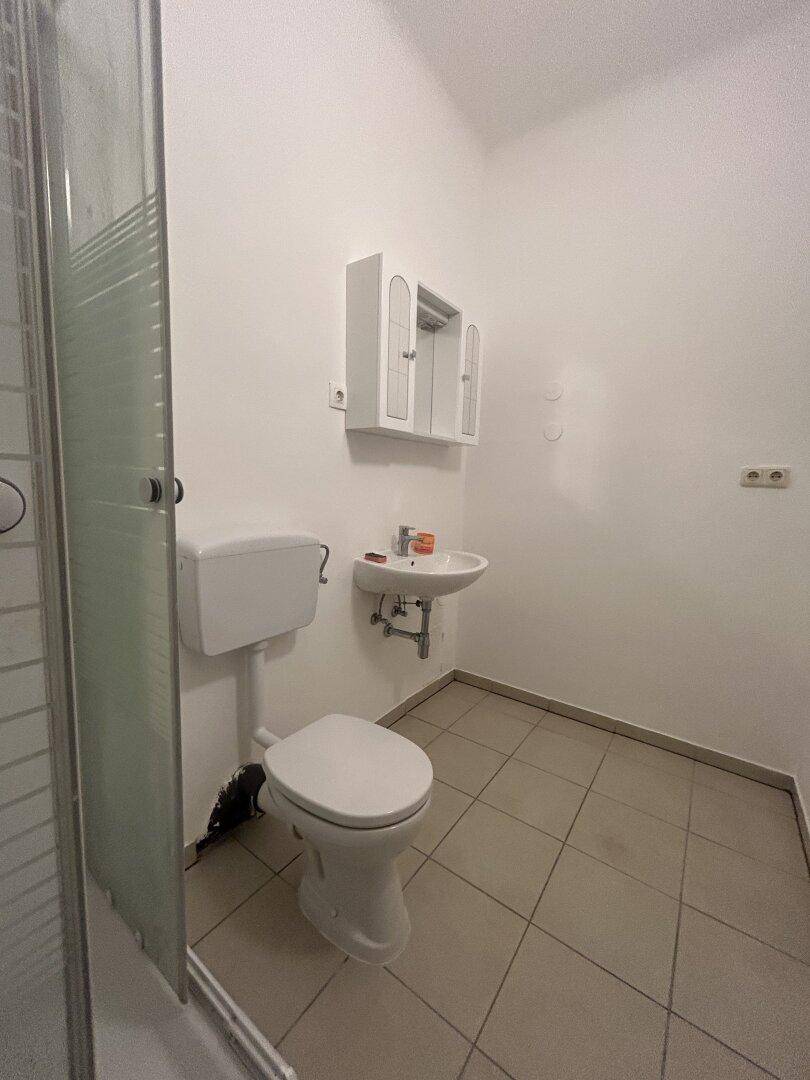 Funktionales Badezimmer mit Dusche, WC und Waschbecken, bereit zur individuellen Gestaltung.