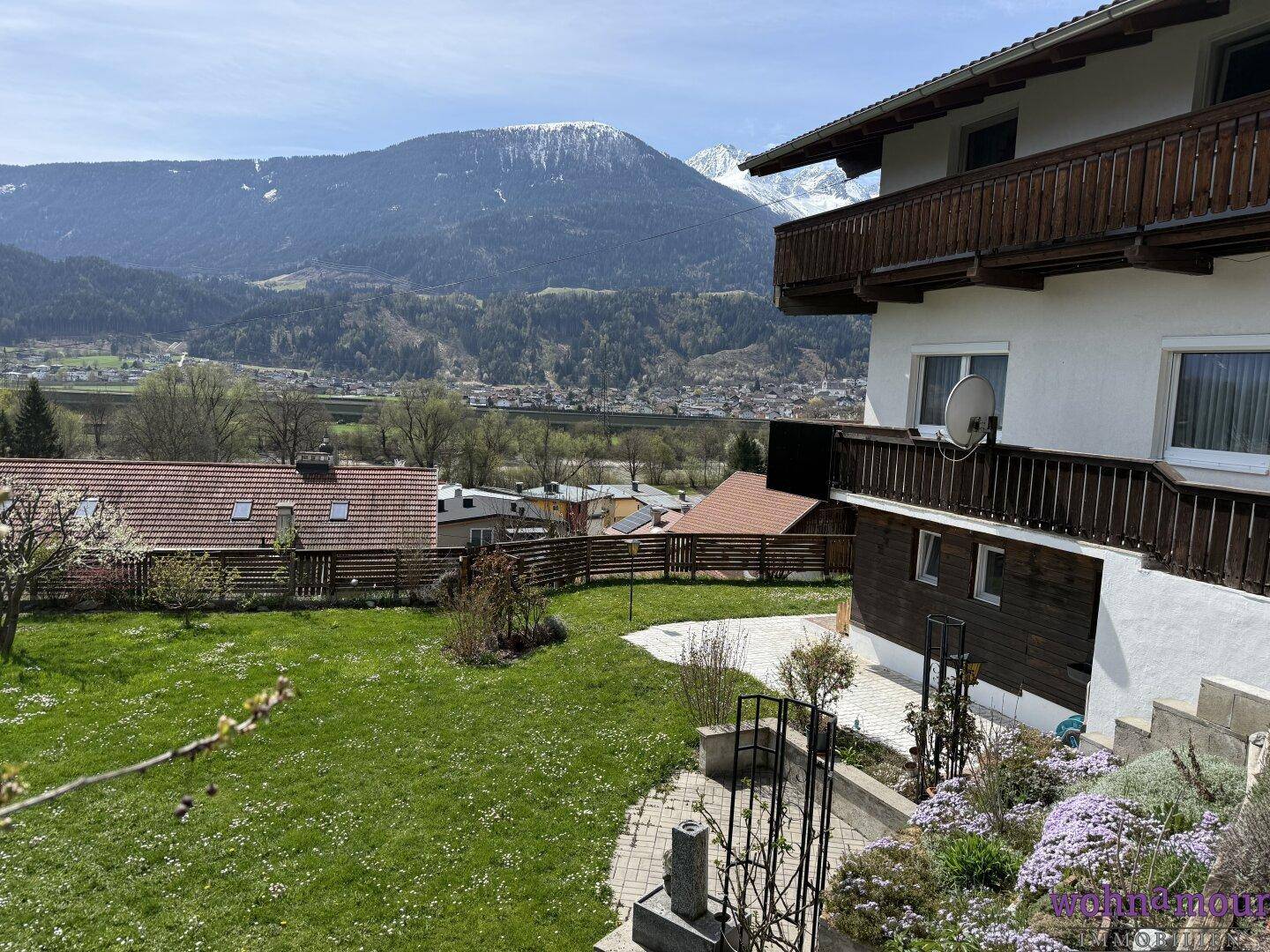 Großer Gartenbereich hinter dem Haus mit weitem Blick auf die umliegende Berglandschaft.