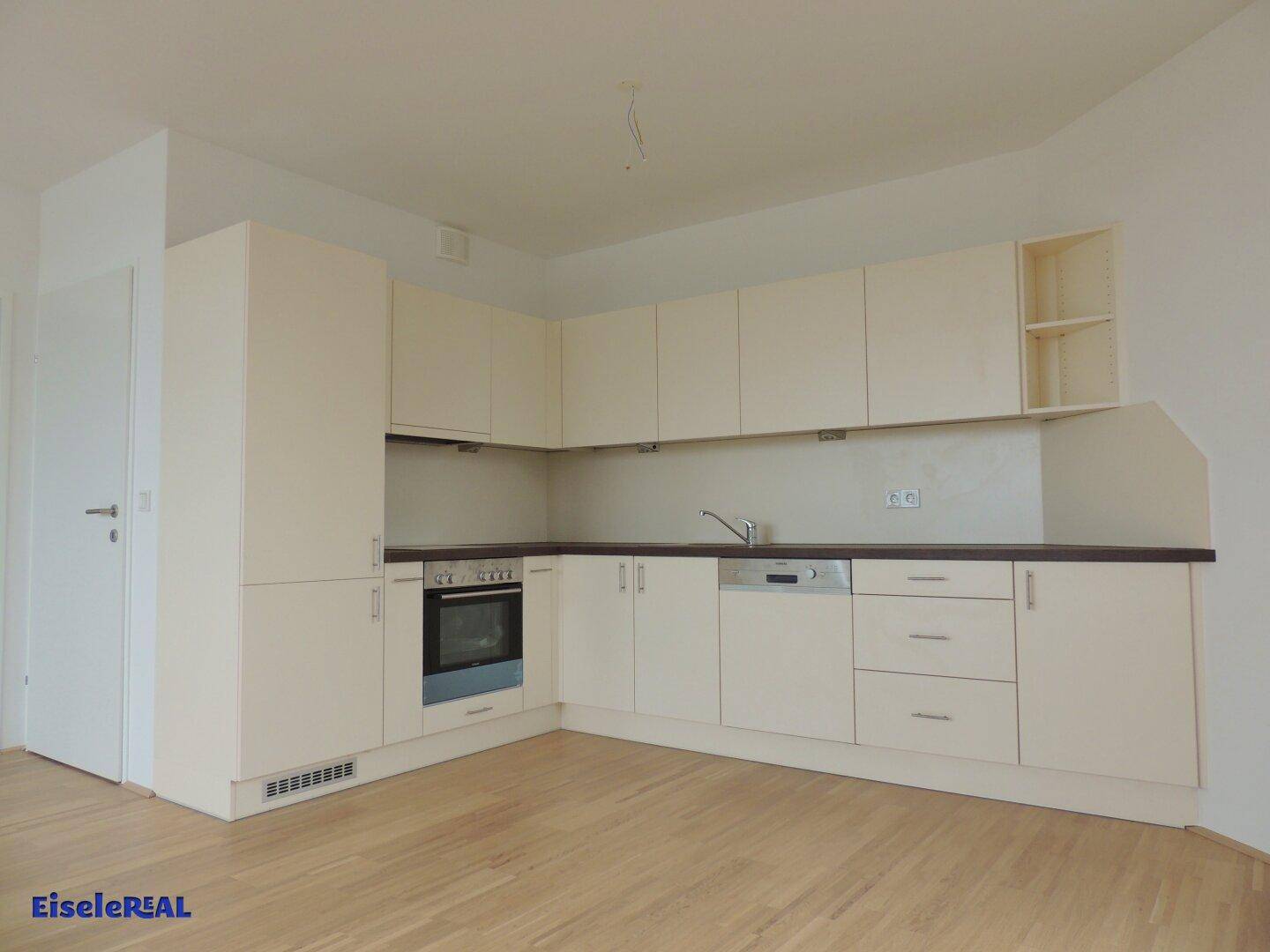 Moderne Einbauküche in hellem Cremeton mit integriertem Backofen und Geschirrspüler.