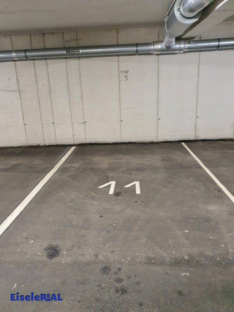 Tiefgaragenstellplatz mit Betonwänden und Nummerierung.