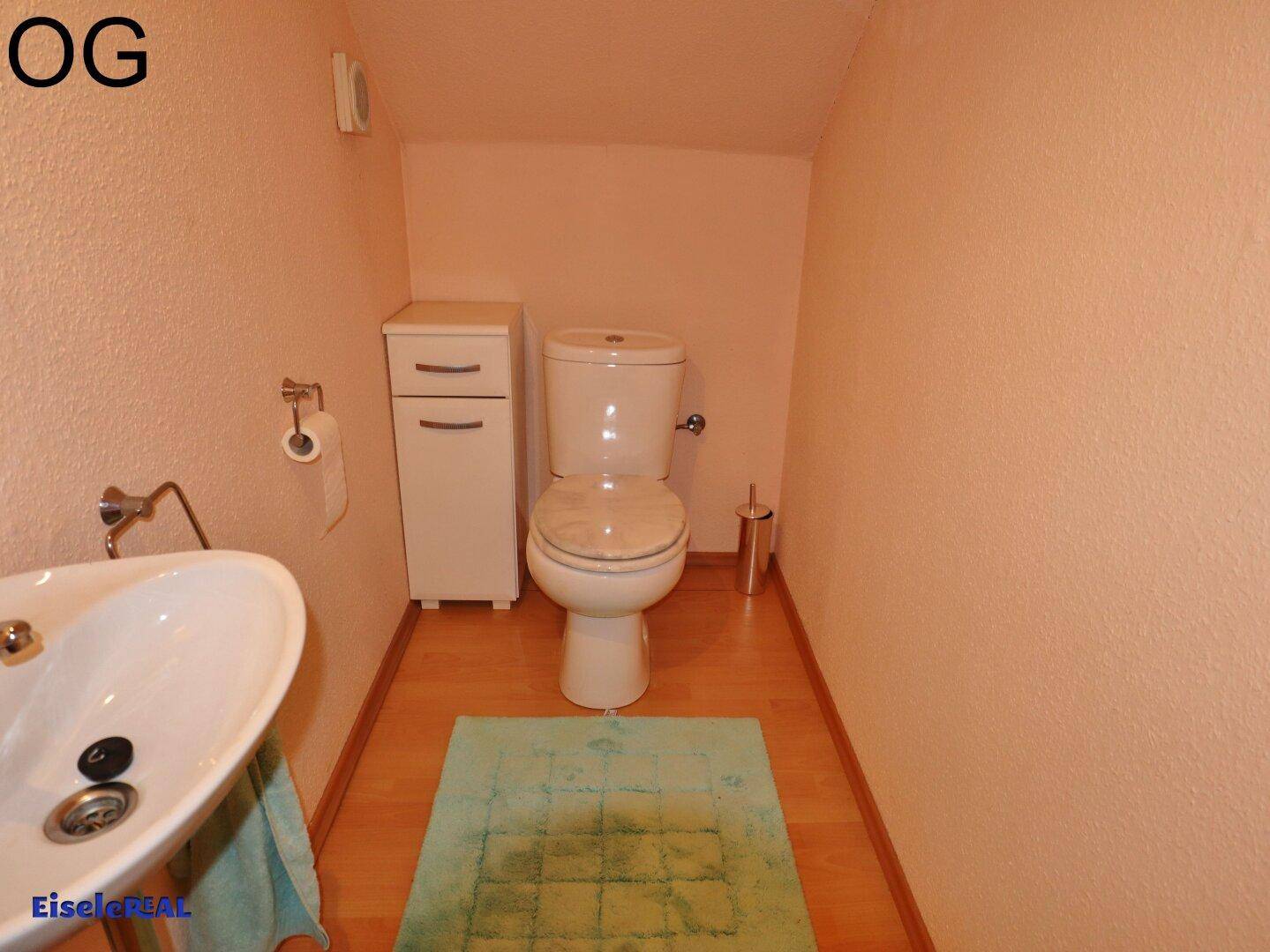 Kleines WC im Obergeschoss mit Waschbecken und hellrosa Wänden, funktional und sauber.