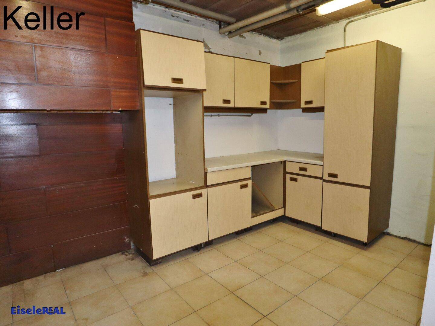Kellerraum mit älteren Einbauschränken und Fliesenboden, ideal als Abstellraum oder Werkstatt.
