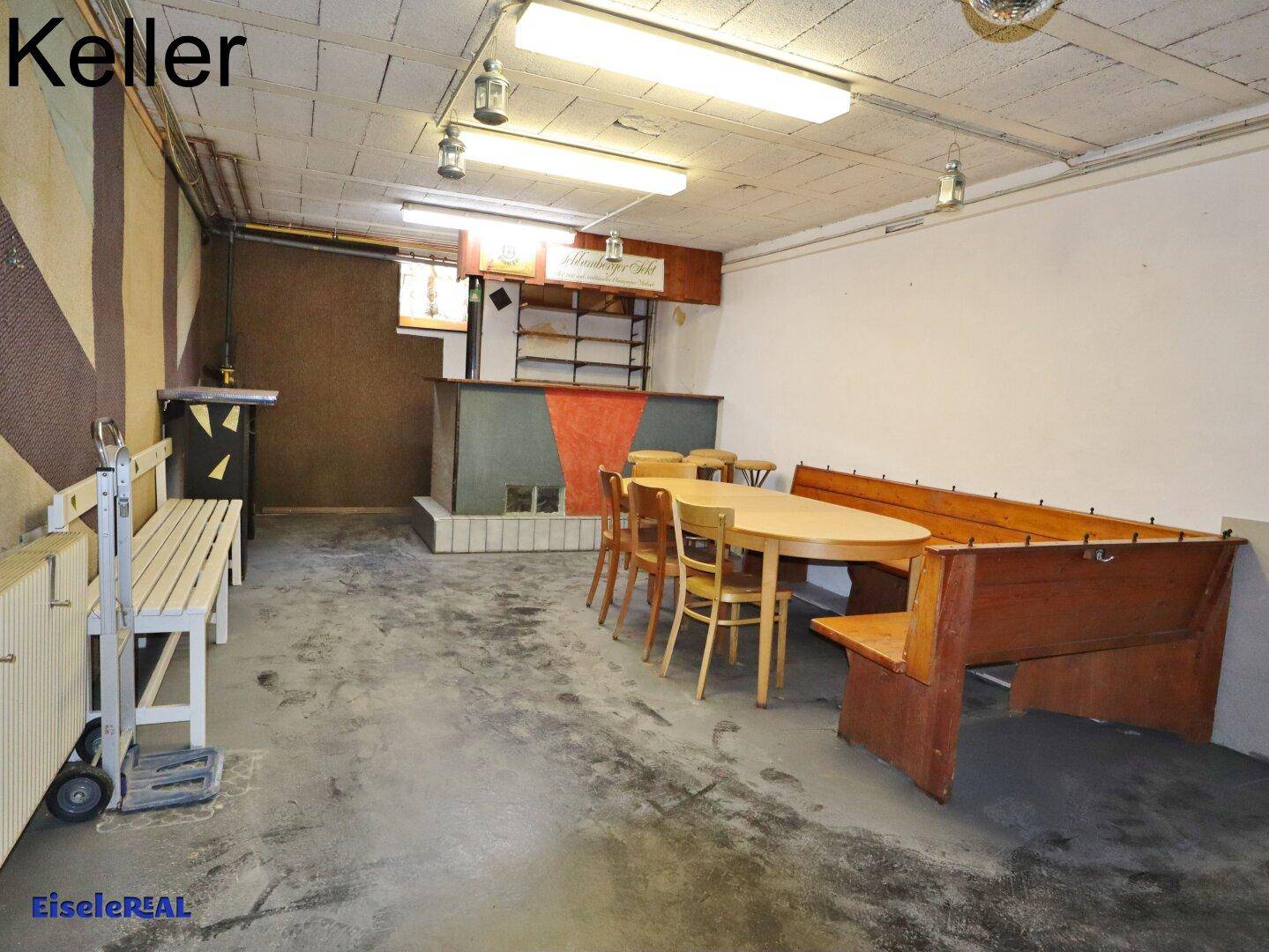 Geräumiger Kellerraum mit Bar, Sitzgelegenheiten und rustikalem Ambiente, ideal für Feiern.