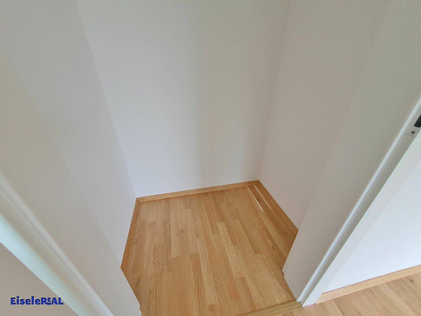 Kleiner, leerer Raum mit Parkettboden, ideal als Abstellraum oder begehbarer Kleiderschrank.