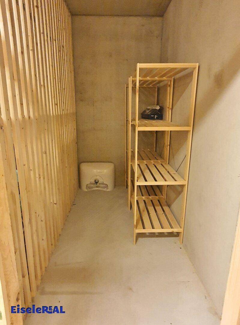 Praktischer Abstellraum mit Holzregalen und einer Holzlattenwand für zusätzlichen Stauraum.