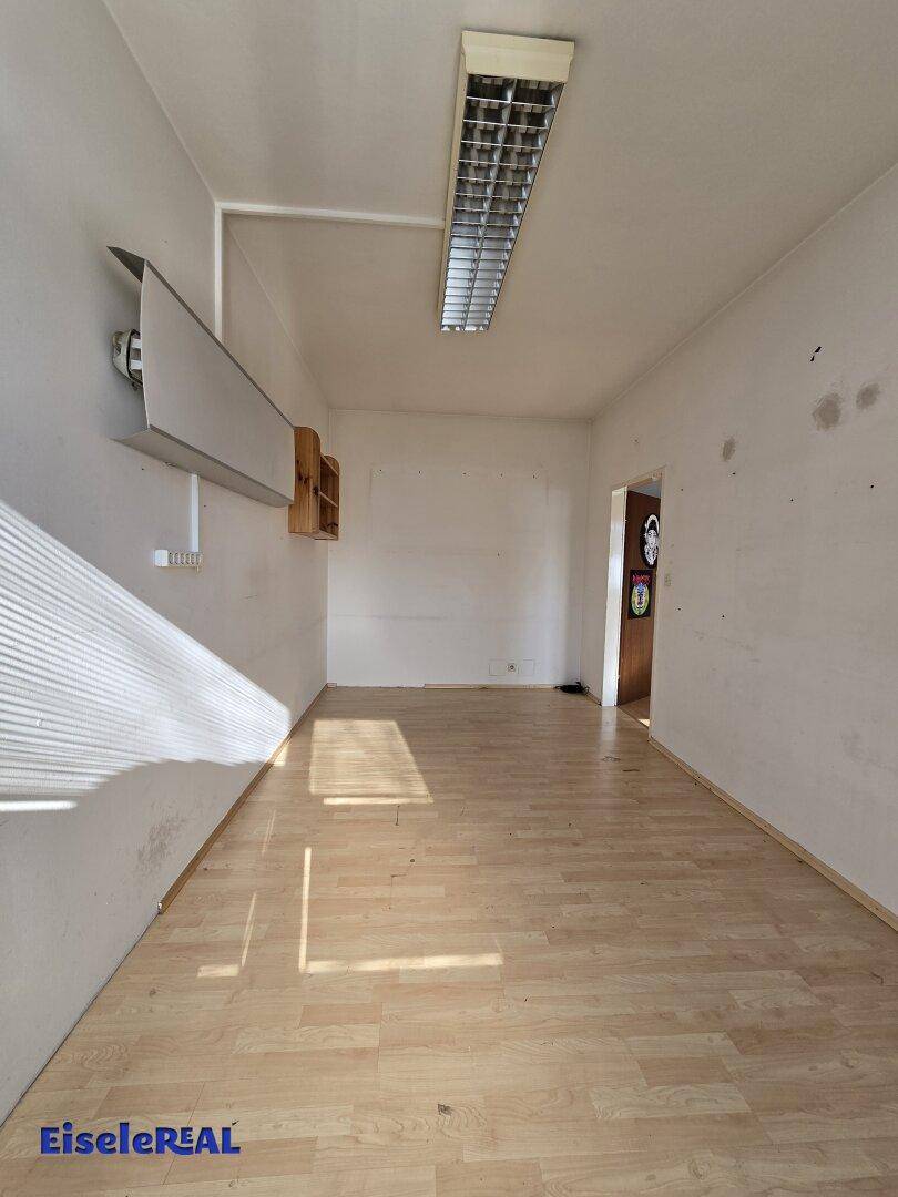 Heller, leerer Raum mit Laminatboden und Fenster, bereit für individuelle Einrichtung.