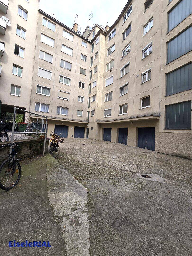 Innenhof eines Mehrfamilienhauses mit Garagen und Fahrradabstellplätzen.