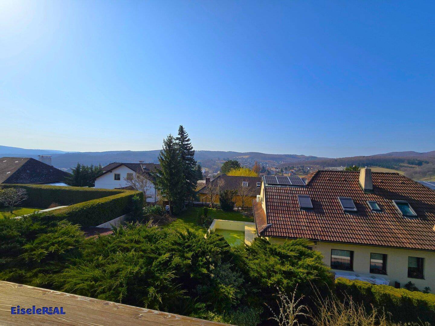 Panoramablick von der Terrasse über die Dächer und die grüne Umgebung.