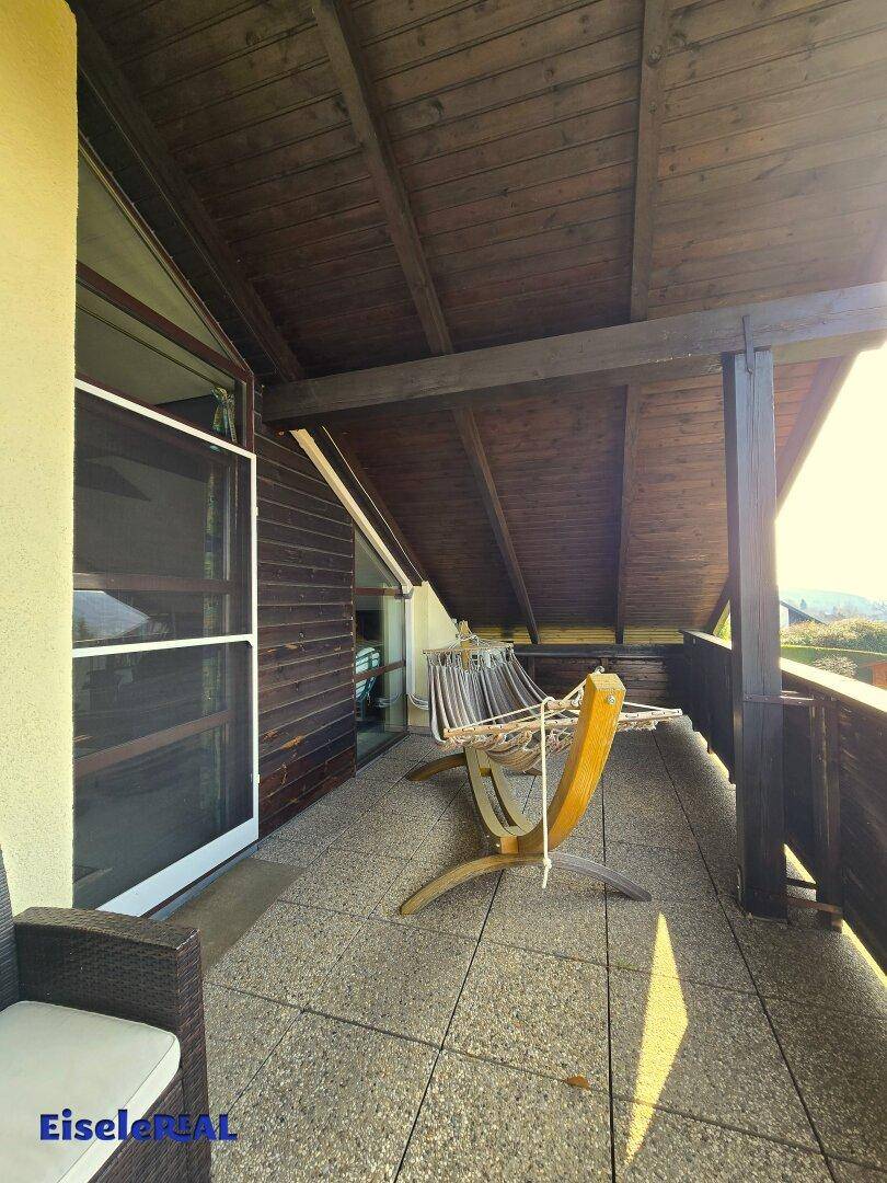 Überdachter Balkon mit Fliesenboden und Hängematte für entspannte Stunden.