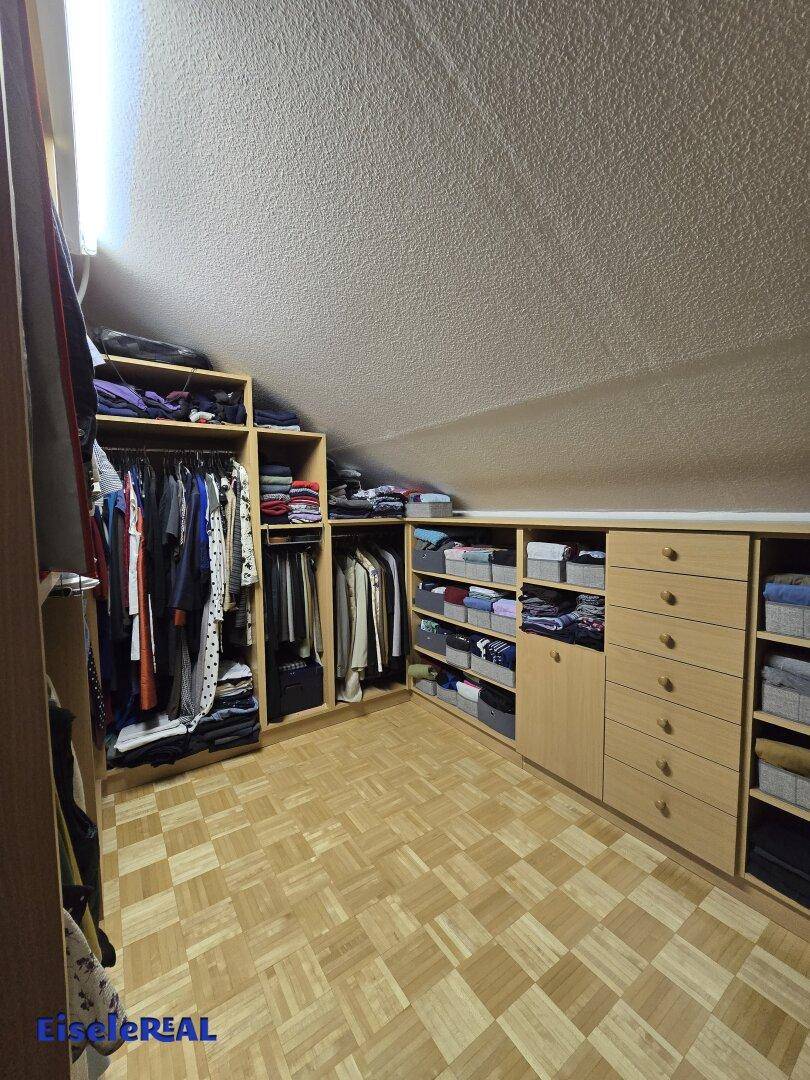 Praktischer begehbarer Kleiderschrank im Dachgeschoss mit viel Stauraum.