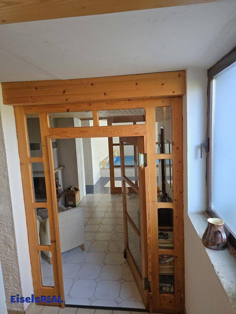 Holztür mit Glaseinsätzen im Keller, die zum Poolbereich führt.
