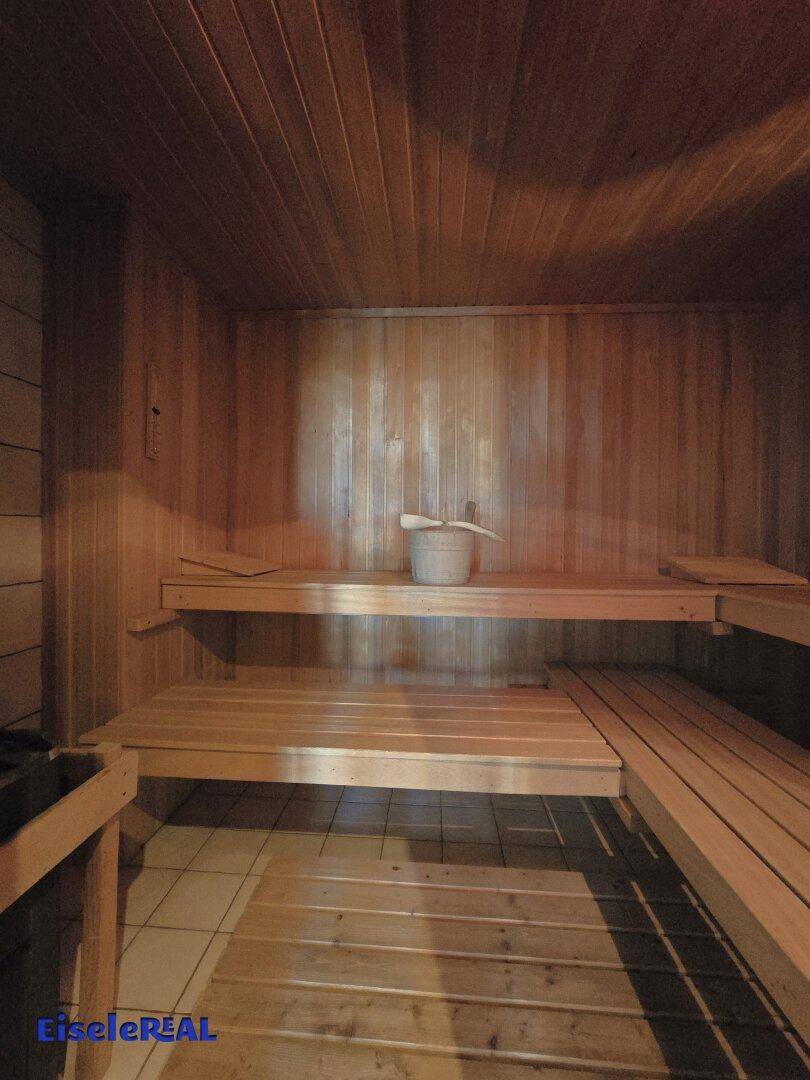 Gemütliche Holzsauna mit mehreren Bänken für entspannende Momente.