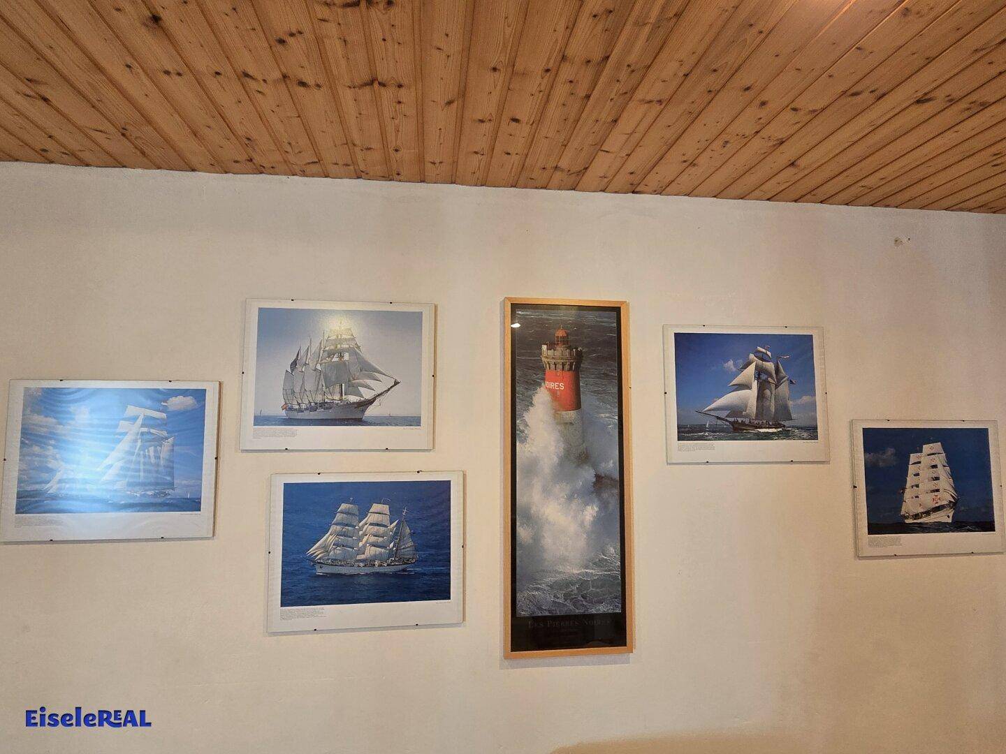 Wanddekoration mit maritimen Bildern im Keller-Wohnbereich.