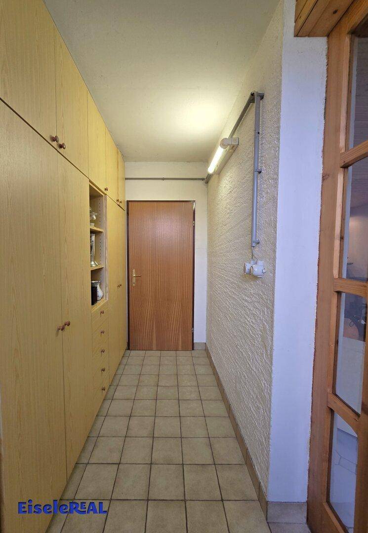 Kellerflur mit praktischen Einbauschränken und Fliesenboden für zusätzlichen Stauraum.
