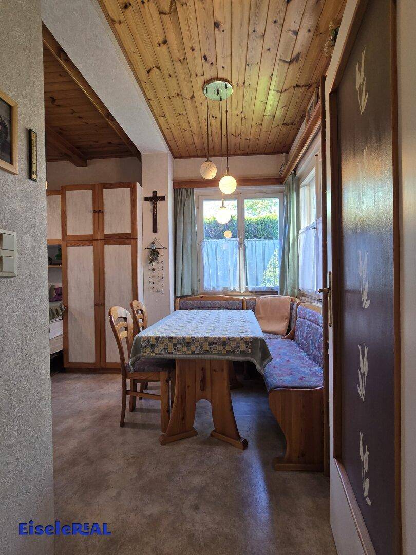 Gemütlicher Essbereich mit Eckbank, Holztisch und Blick in den Garten.