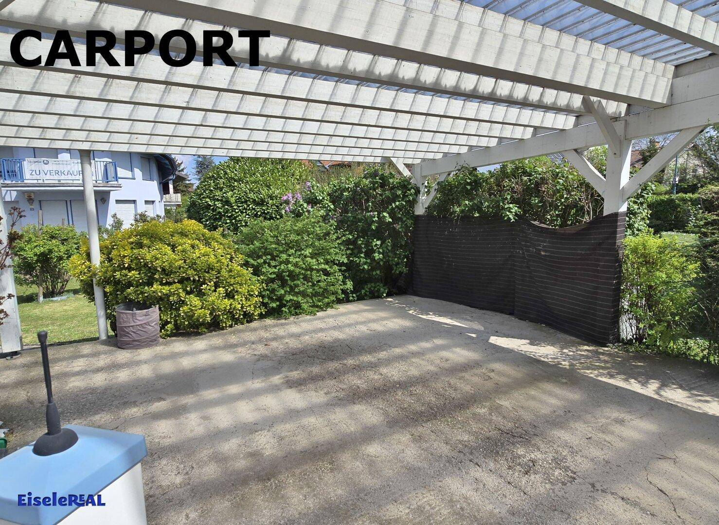 Ein Carport mit transparentem Dach und Holzkonstruktion, bietet geschützten Parkraum.