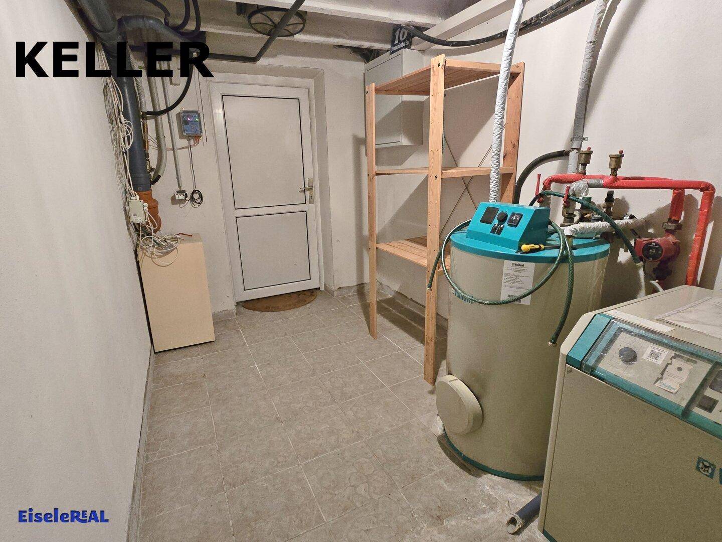 Geräumiger Kellerraum mit Heizungsanlage, Holzregal und einer weißen Tür.