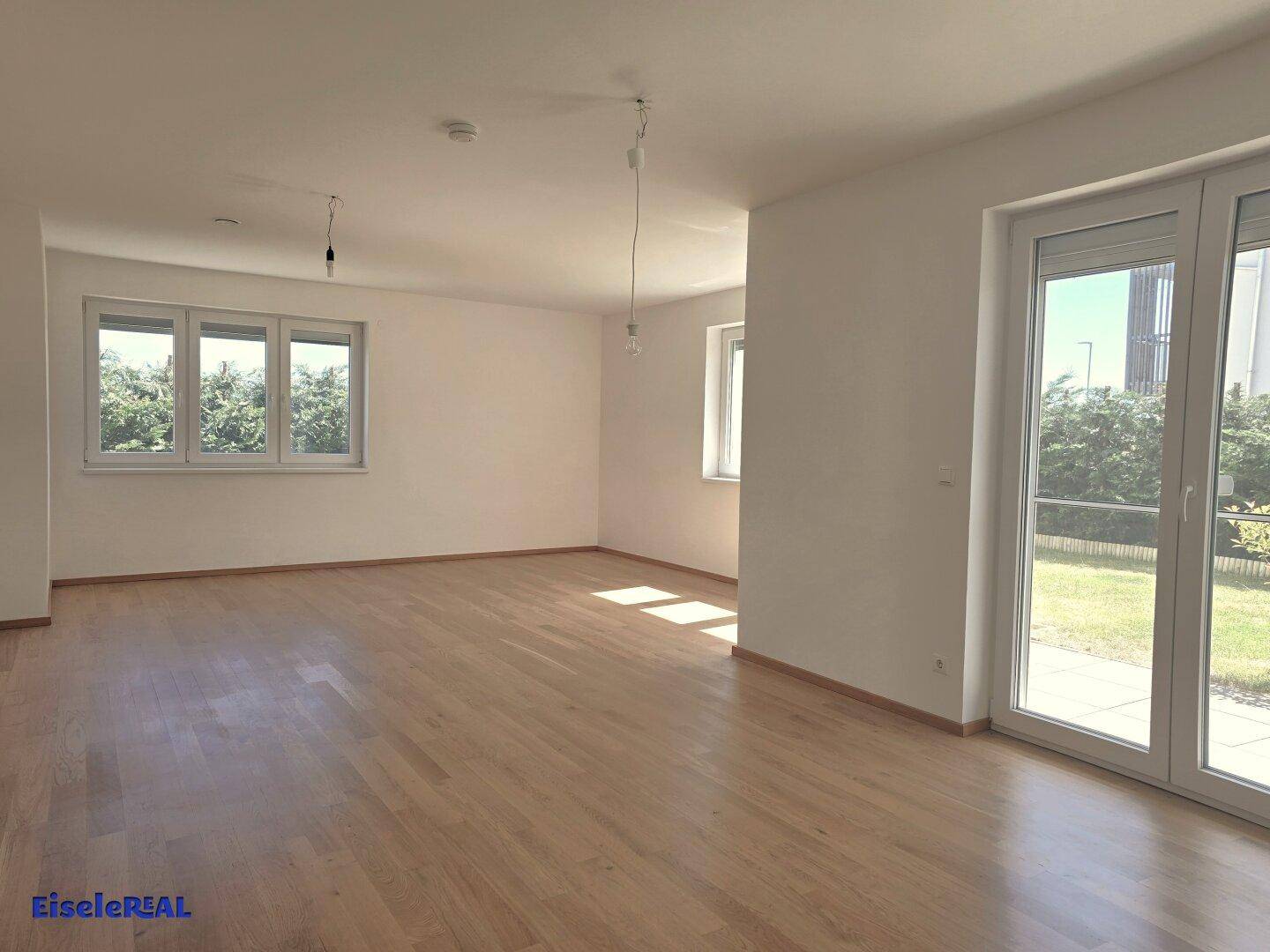 Heller Wohnraum mit Eichenparkett und direktem Zugang zur Terrasse oder zum Garten, viel Tageslicht.