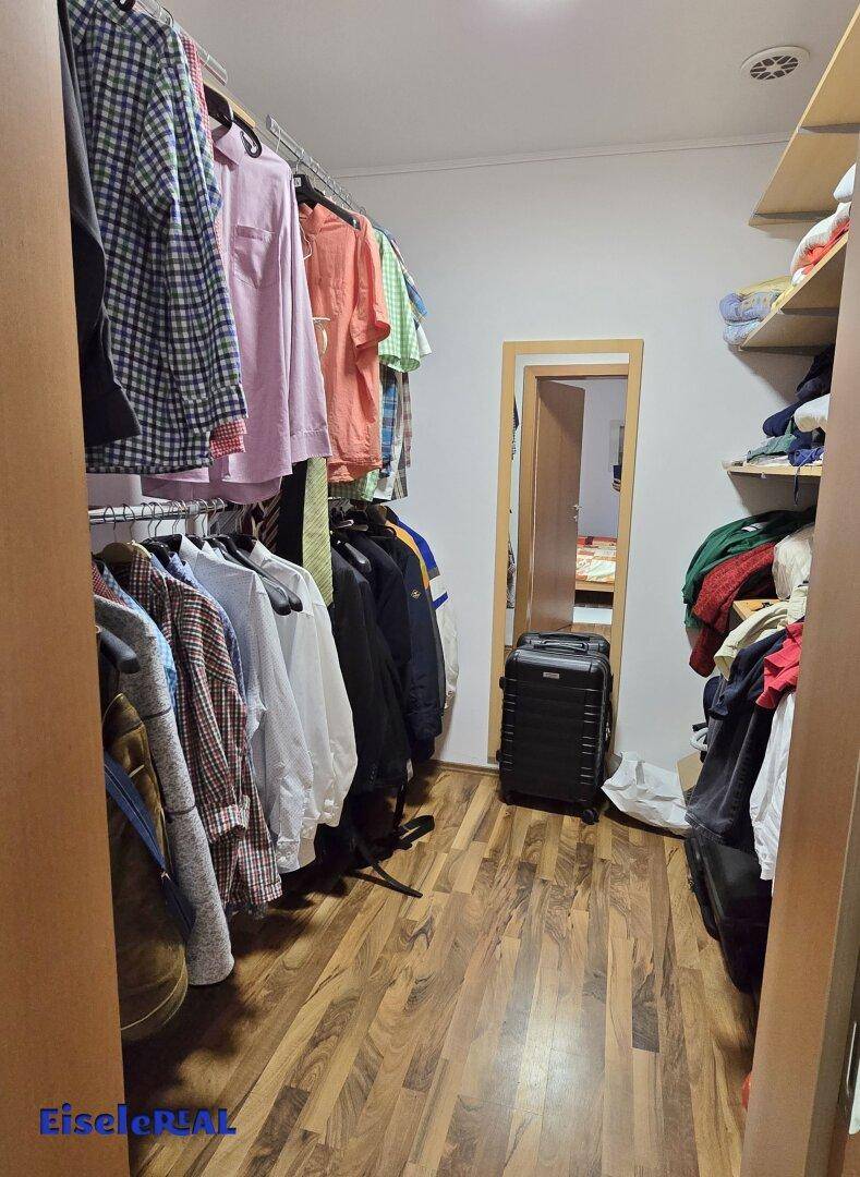Praktischer begehbarer Kleiderschrank mit viel Stauraum und Regalsystemen.