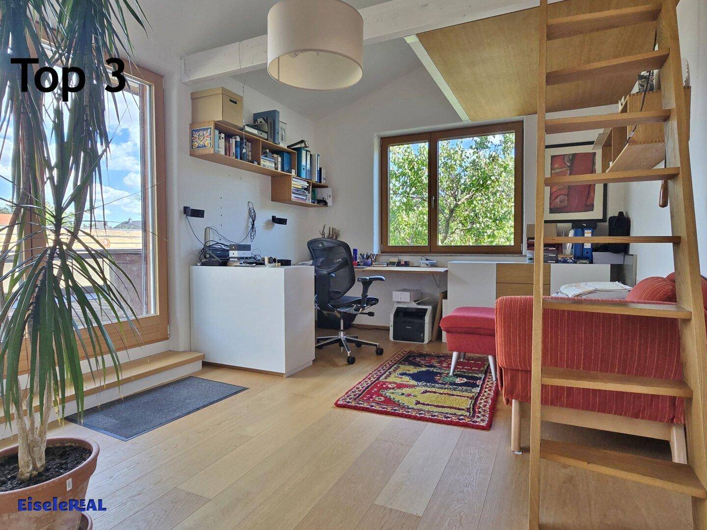 Helles Arbeitszimmer mit Holzboden, Schreibtisch und Zugang zu einem Außenbereich.