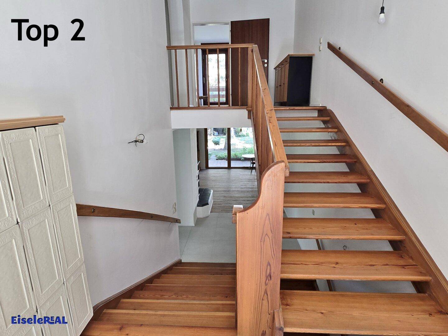 Holztreppe mit Geländer, die verschiedene Ebenen des Hauses miteinander verbindet.