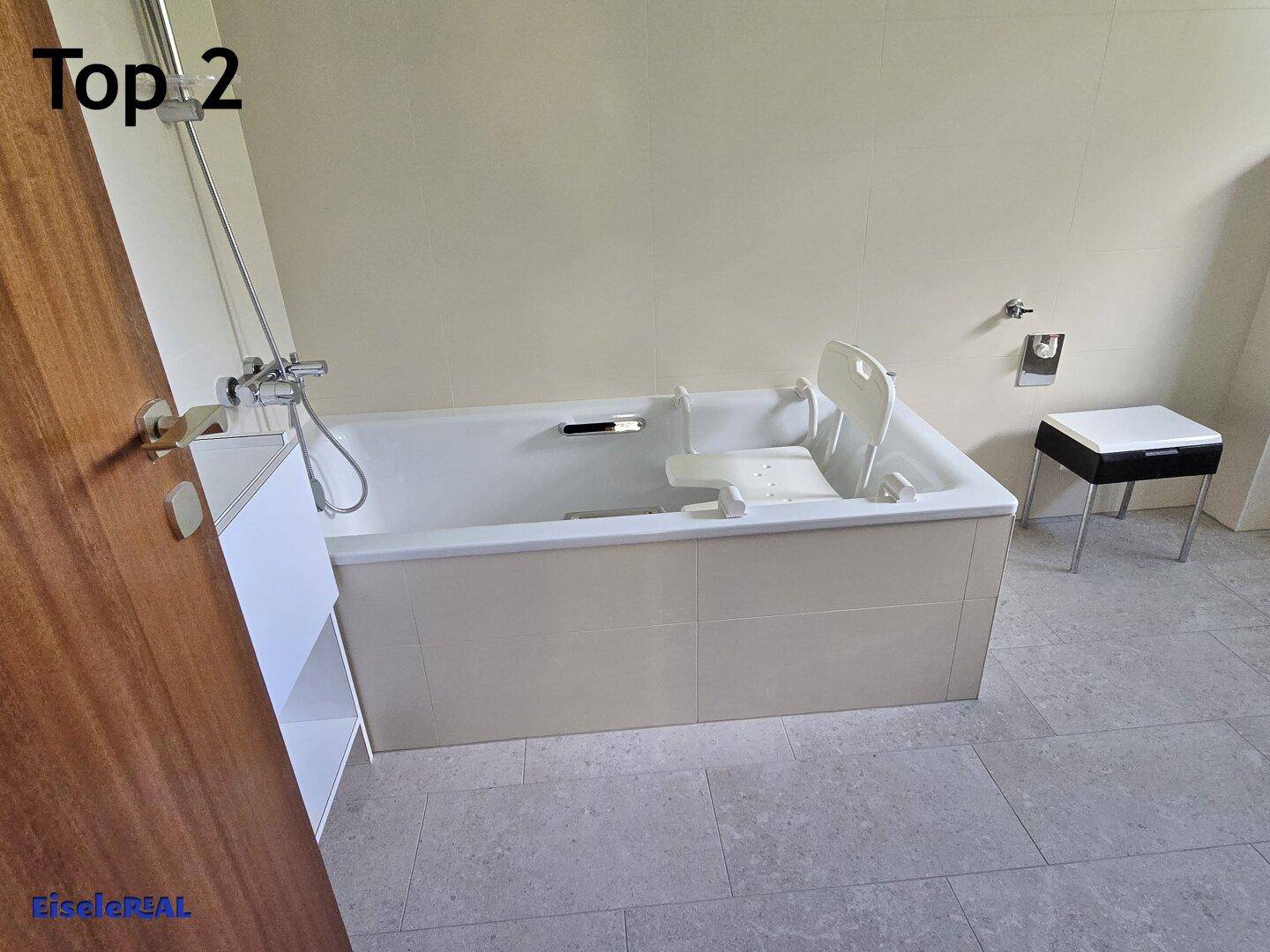 Modernes Badezimmer mit Badewanne, Fliesenboden und hellen Wänden.